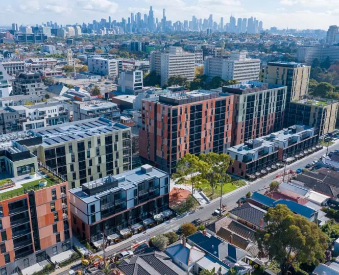 Drone image of the Bangs Street housing development surrounded with green trees, oval and local community