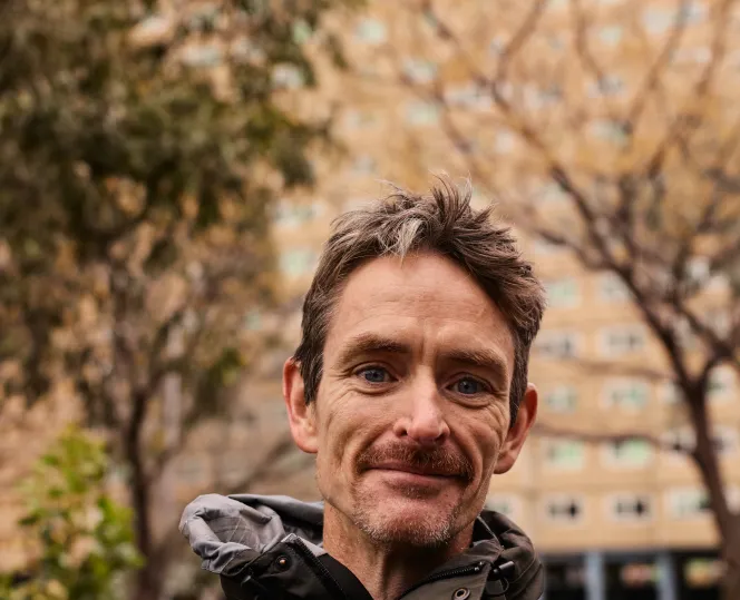 Person with a moustache in front of a social housing tower