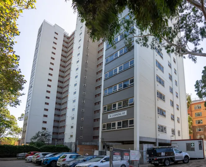 Picture of 76 Canning Street, North Melbounre from the ground, showing some cars in the car park