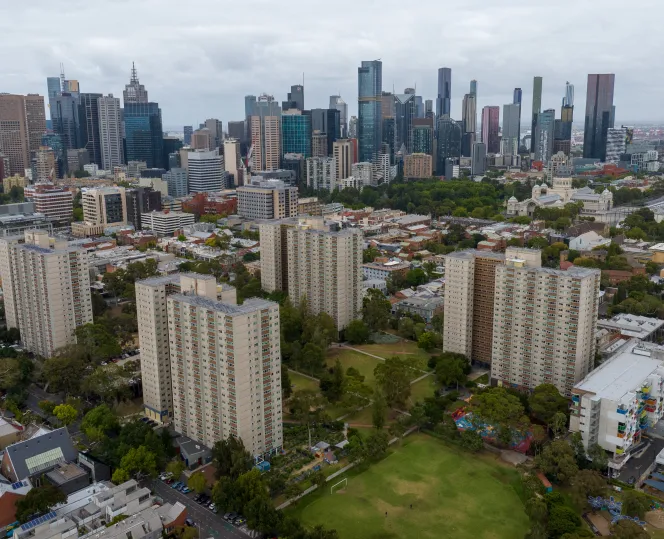 4 apartment buildings with lower buildings around them. The city skyline can be seen in the background