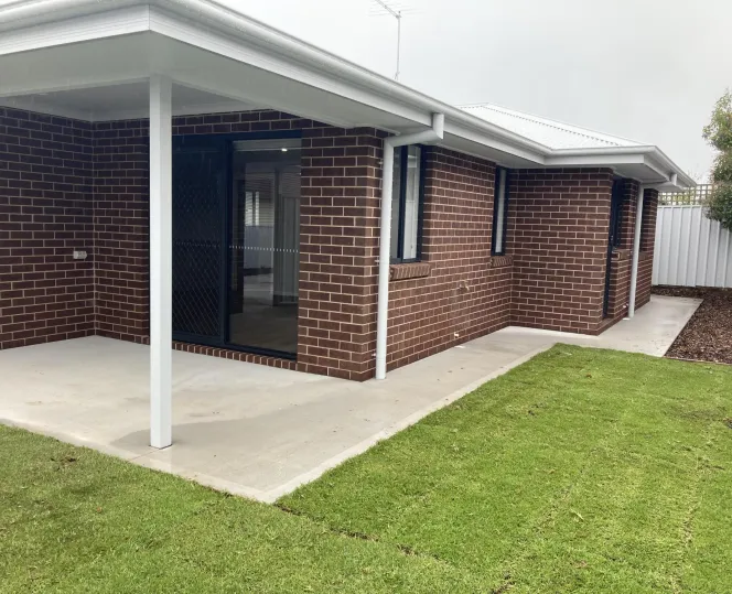Exterior image of house built in red bricks and lawn outside