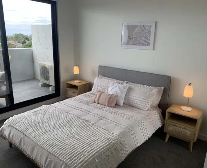 Image of bed in a bedroom with bed side tables and lamp 