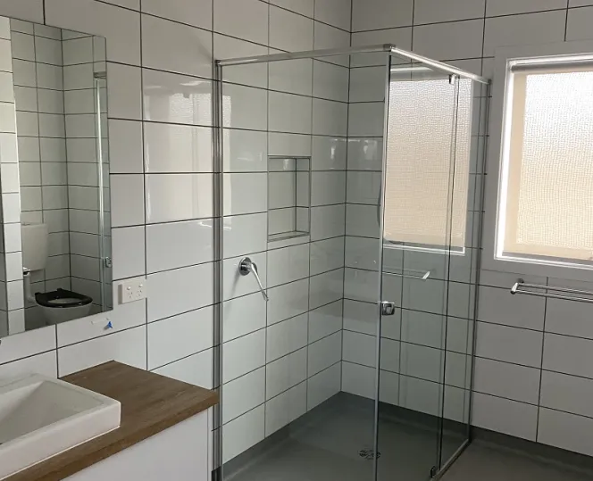 Image of bathroom with shower area and mirror above washbasin,with vanity