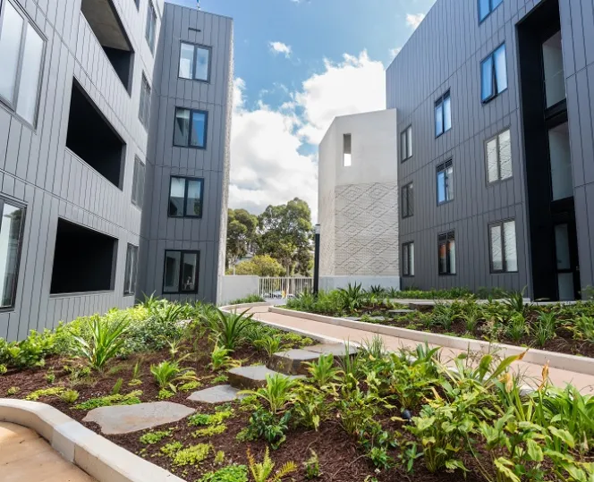 An image of the internal courtyard, brimming with greenery, nestled between buildings on each side.