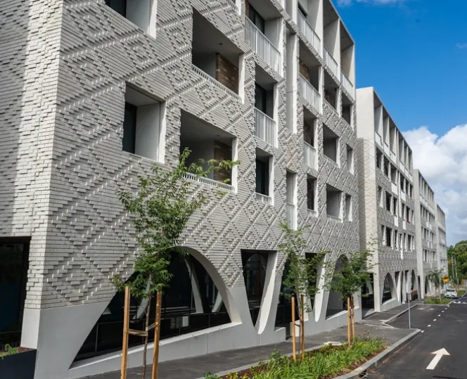 An image of the textured concrete façade of the buildings facing Kirner Street, located next to North Melbourne Primary School. 