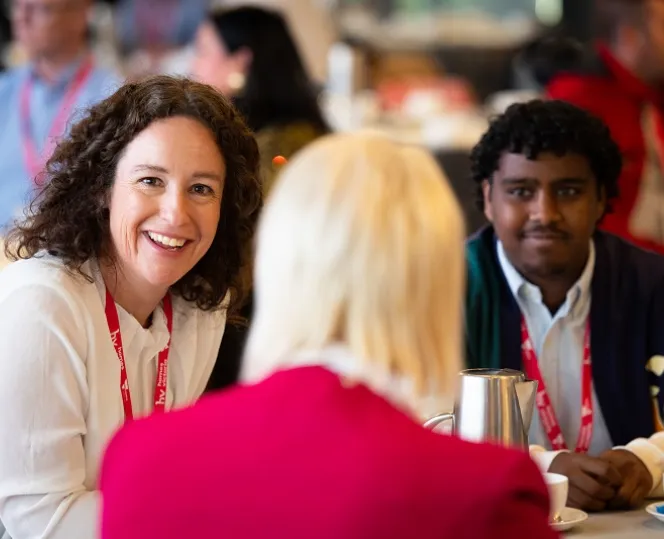 Image of lady smiling while having discussion with other people around