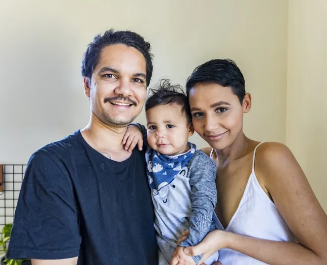 Image of Smiling family with a mother, father, and their child.