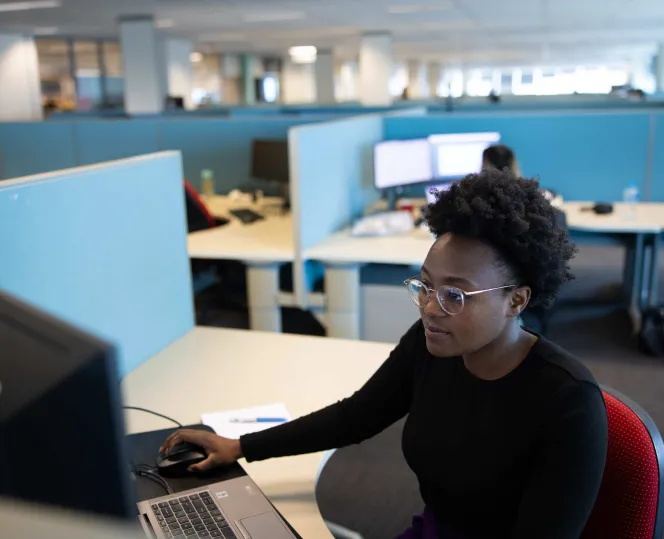 Person sitting behind a computer in an open office