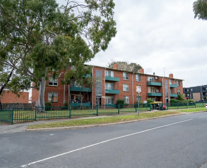 Image of apartment building with local community around