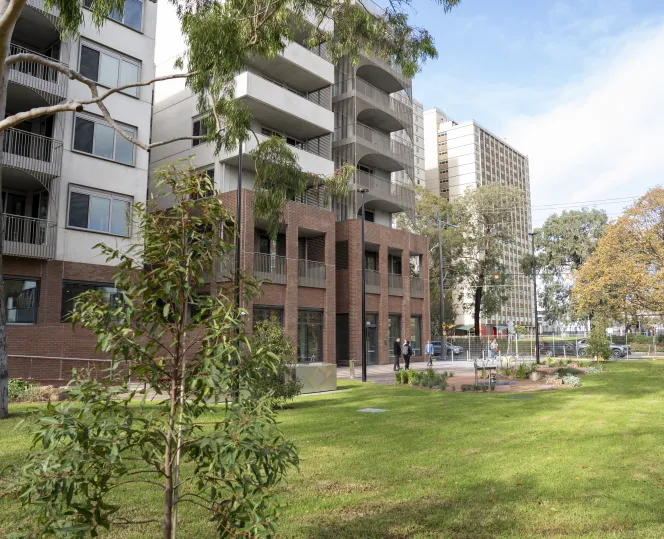 Image of  modern apartment set amid open green spaces and lush landscaped gardens.
