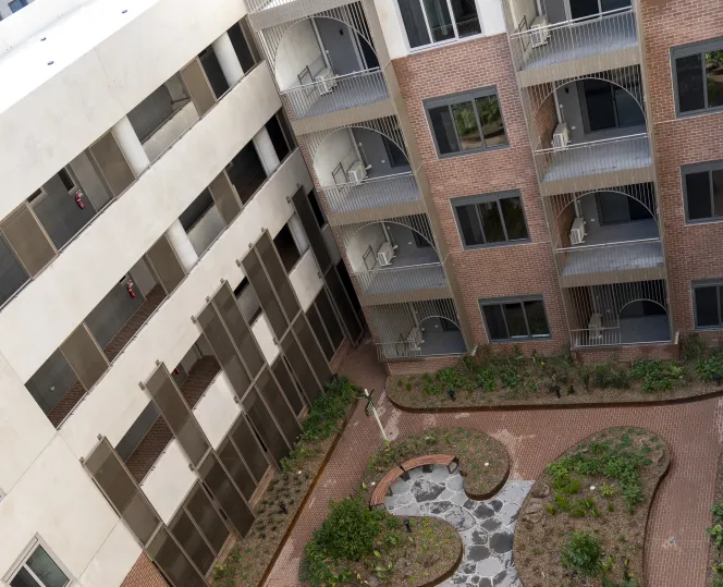 Drone image of  modern apartment set amid open green spaces and lush landscaped gardens.