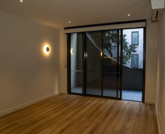 Interior of a modern apartment showcasing a spacious living area that opens onto a balcony.  
