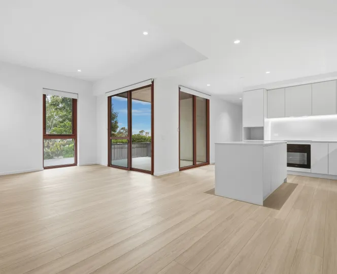 A kitchen, dining and living area inside a 2-bedroom home