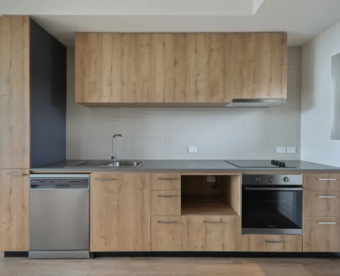 Modern kitchen with white cabinets, built-in oven and dishwasher, and clean counter tops.