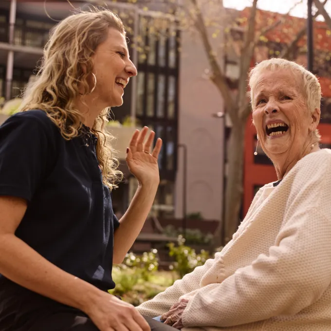 2 people sitting and laughing to each other