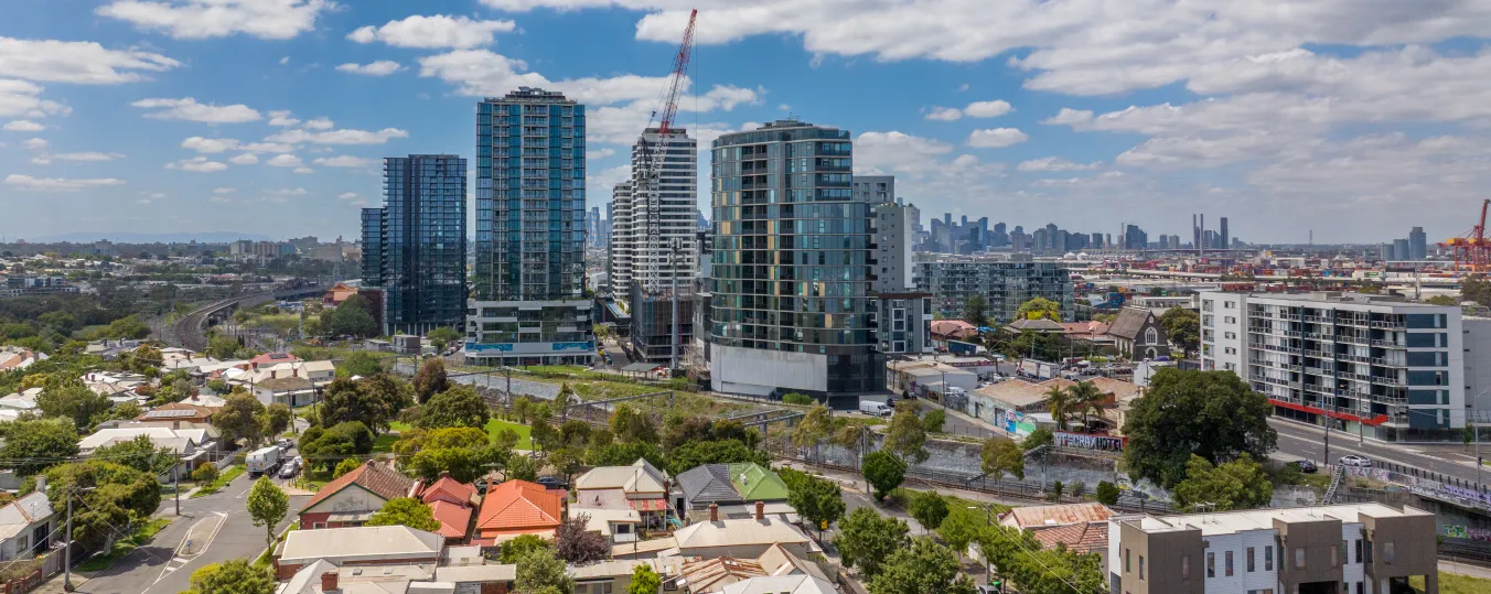  Drone view of a tall building on Wightman Street in Footscray, with a railway line beside it and nearby houses 