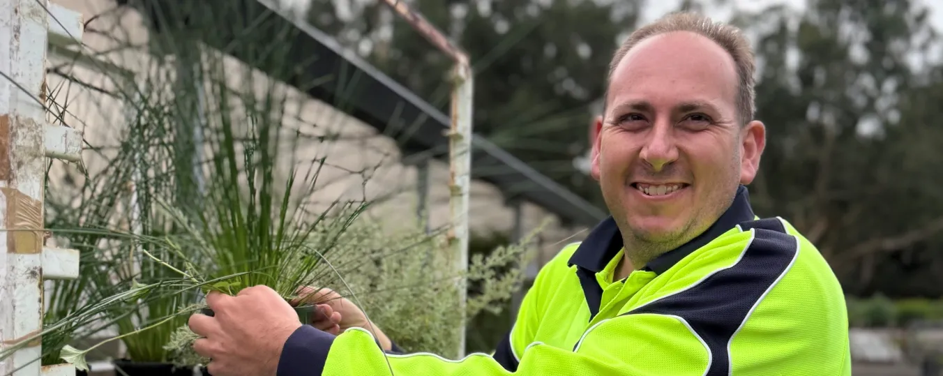 A person planting greenery to help transform the outdoor spaces at the Bluff Road housing development.  