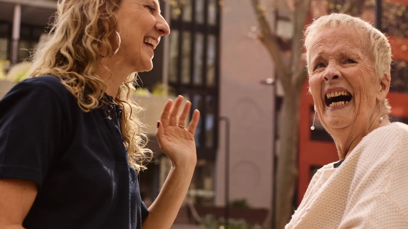 2 people sitting and laughing to each other