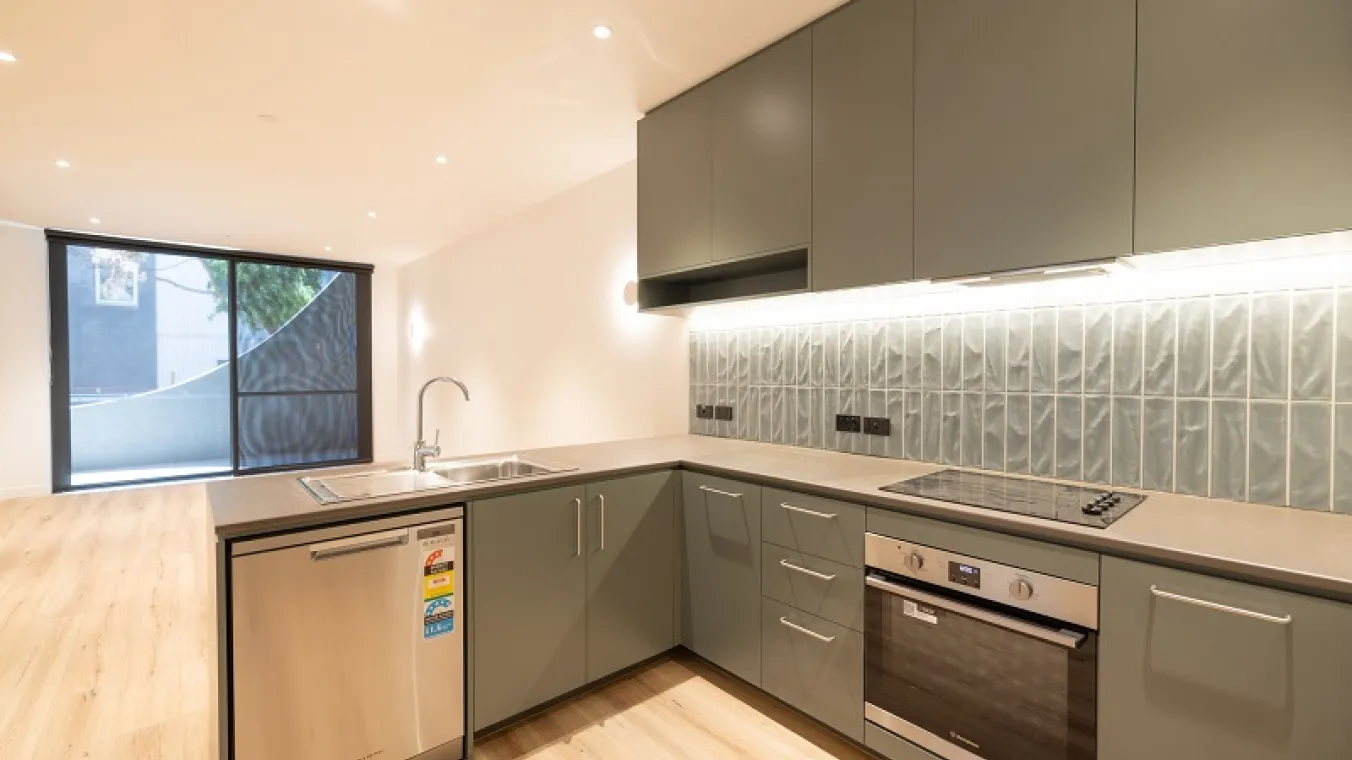 Image of modern kitchen with electric stove, dishwasher,sink,chimney, cabinets, and microwave with drawing room attached