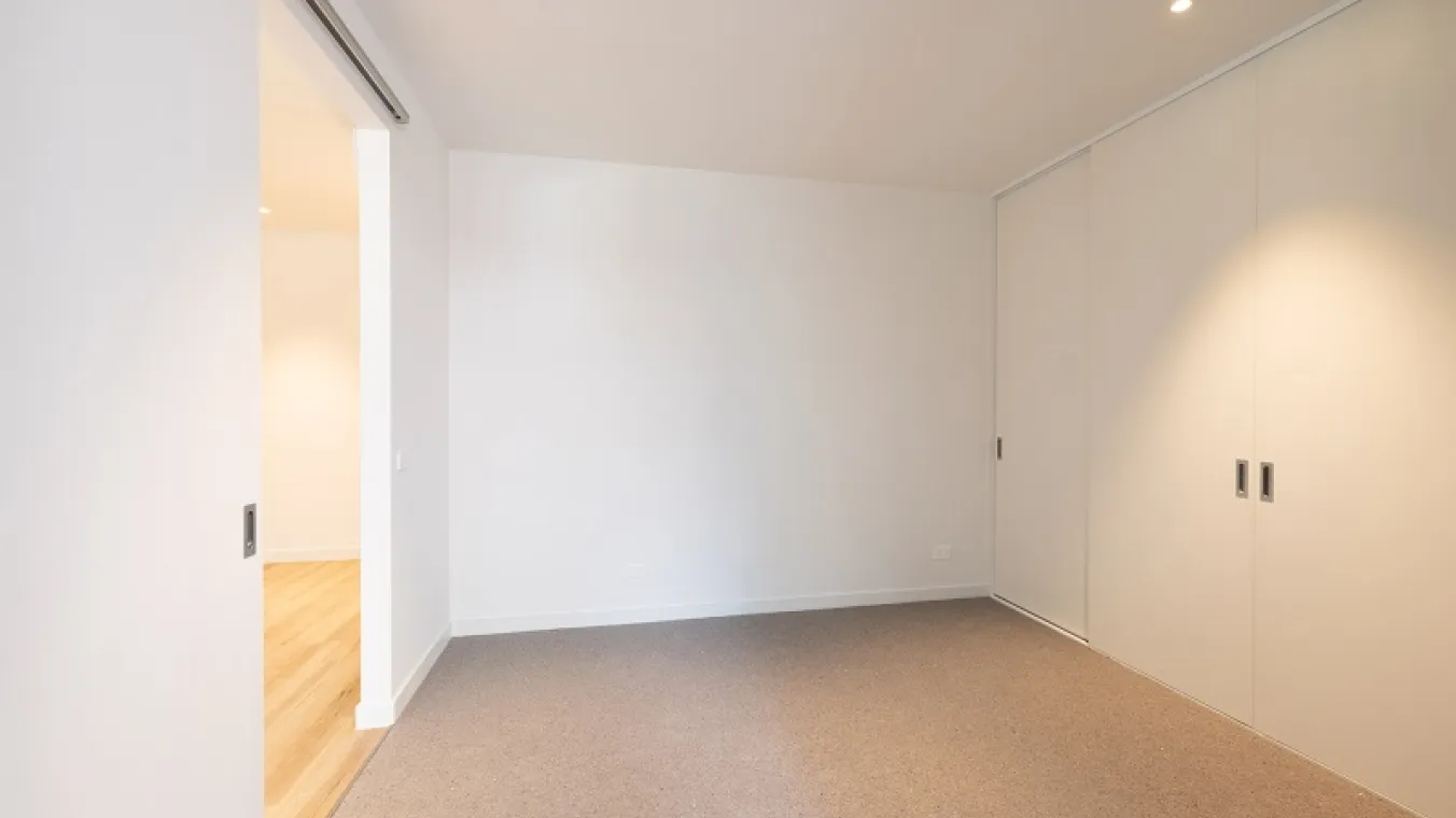 Image of bedroom with carpet, built-in wardrobe, and sliding door.