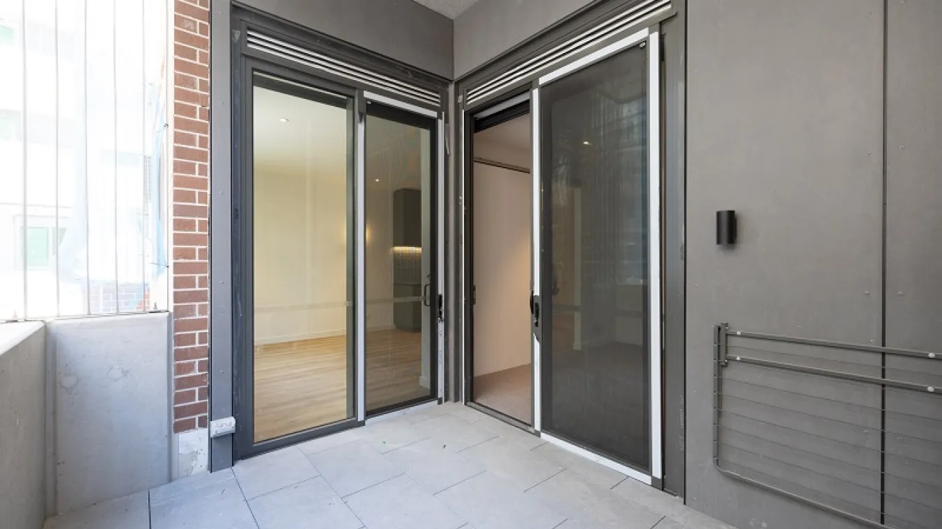 Image of a balcony with dual-entry doors to balcony and a designated area for drying clothes.