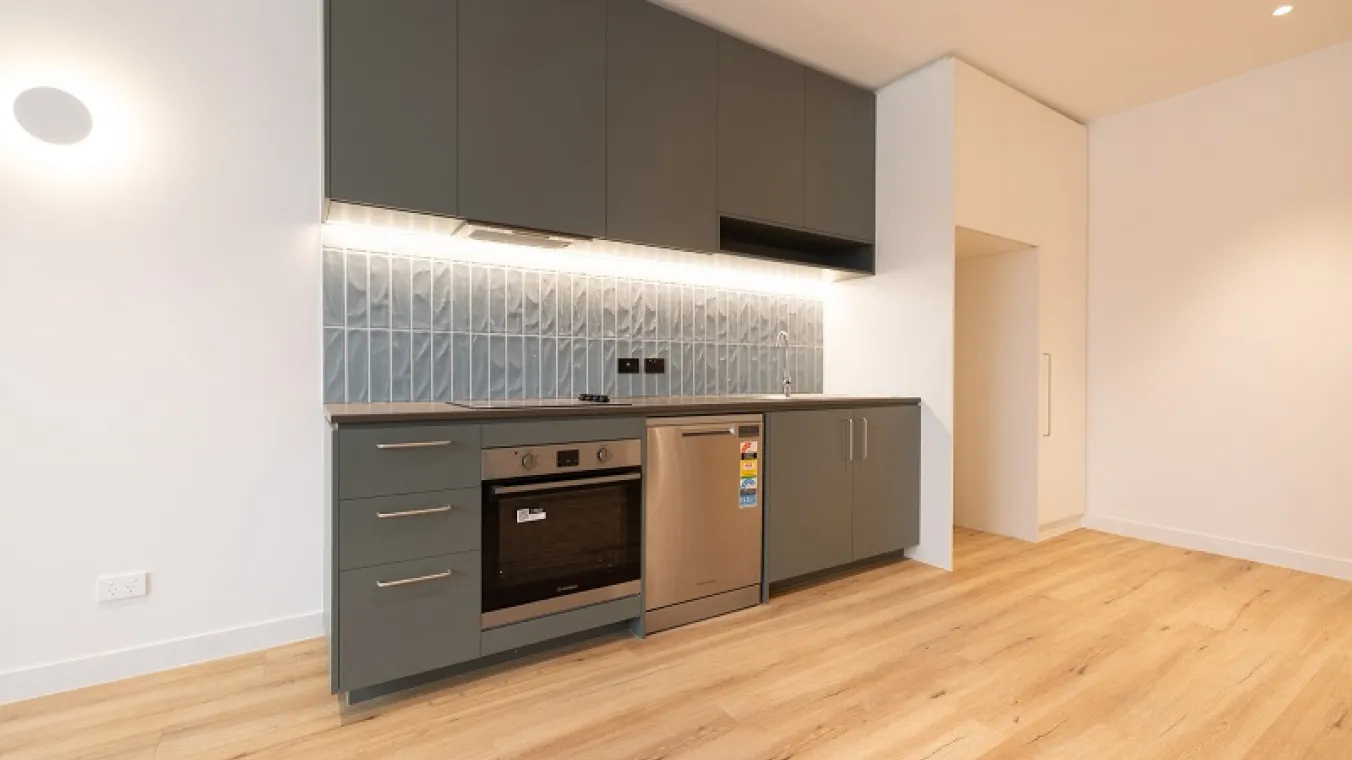 Image of modern kitchen with electric stove, dishwasher,sink,chimney, cabinets, space for fridge and microwave