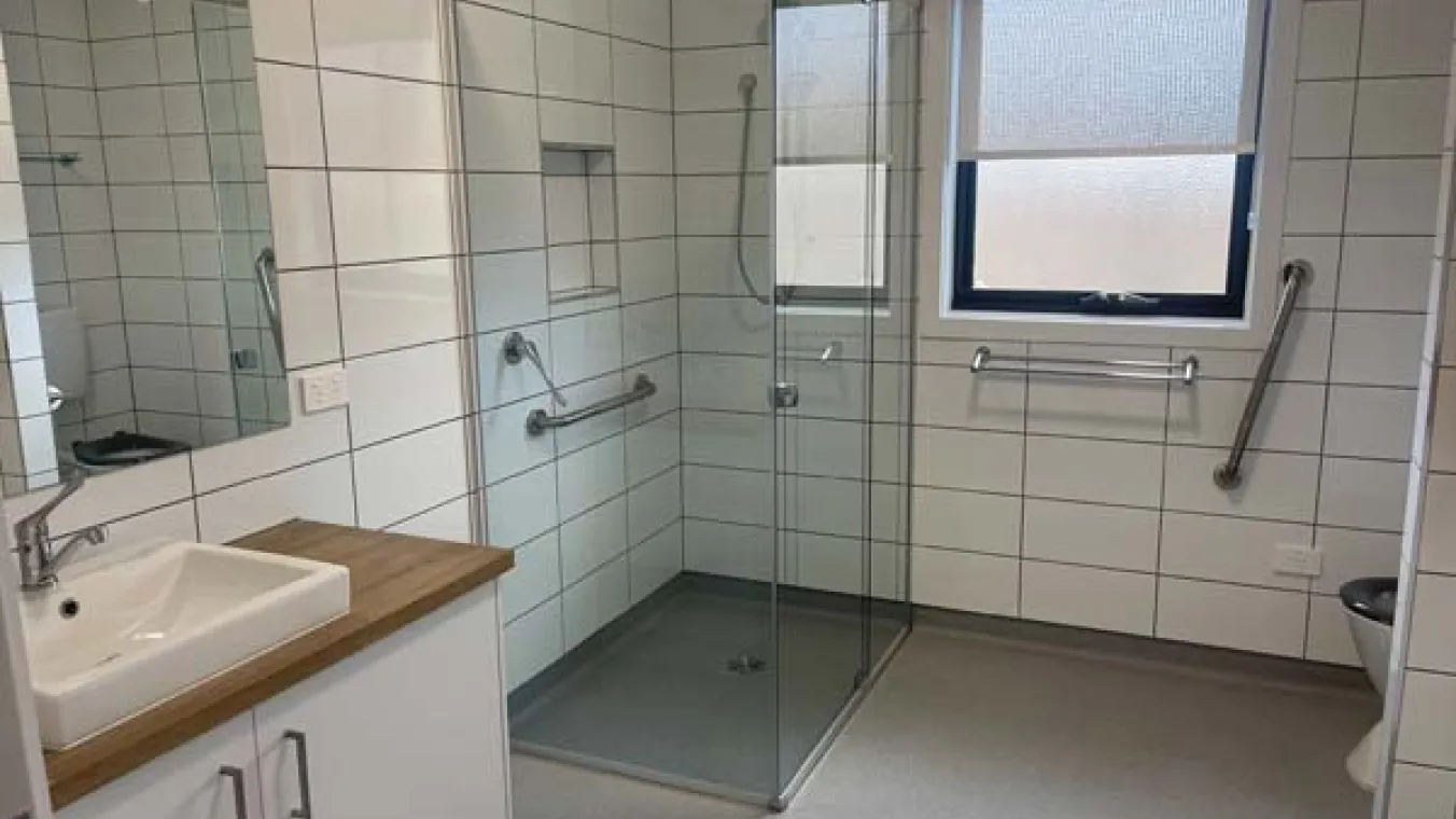 Image of bathroom with shower, wash basin with mirror and toilet