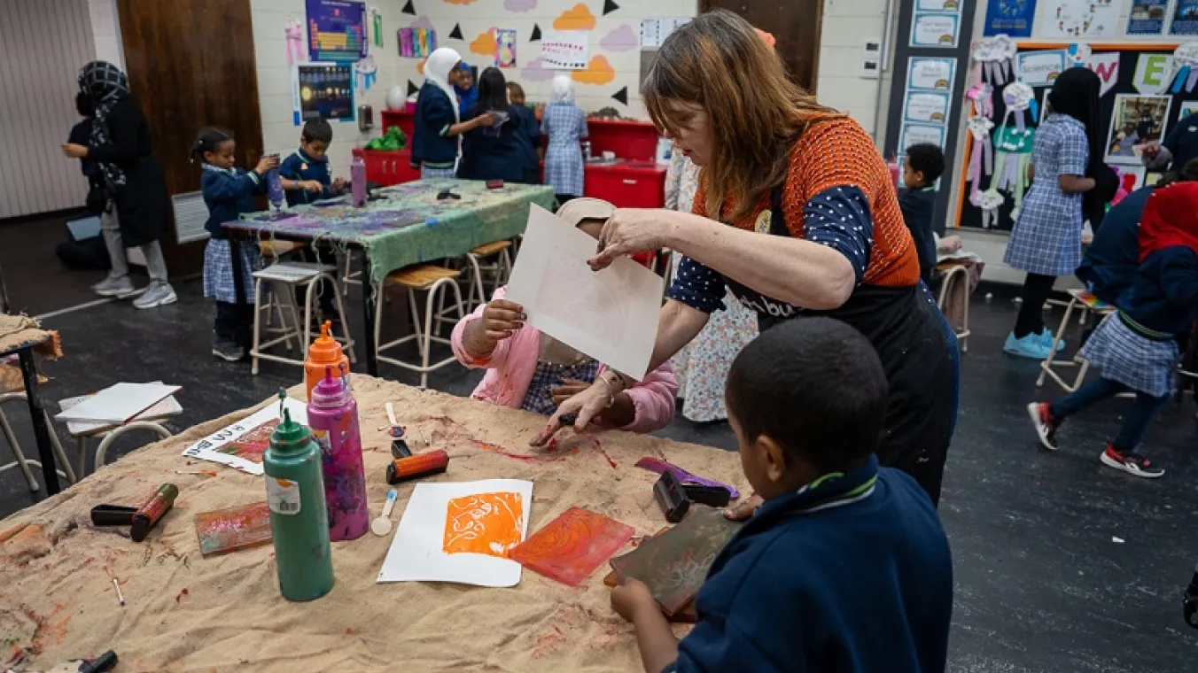 Artists for Kids Culture helping students with their designs, pictured here with Kylie Greer from the artsbus