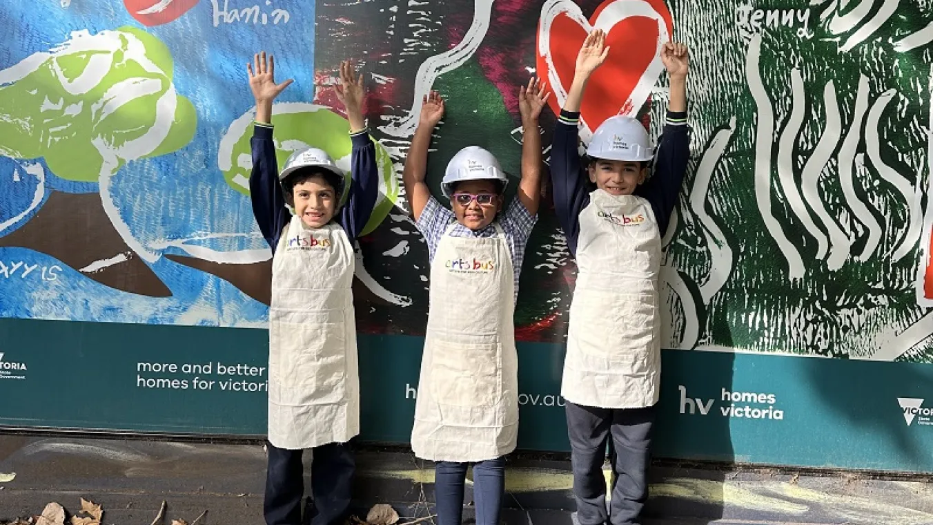 Image of Debney Meadows Primary School students standing in front of their artwork.
