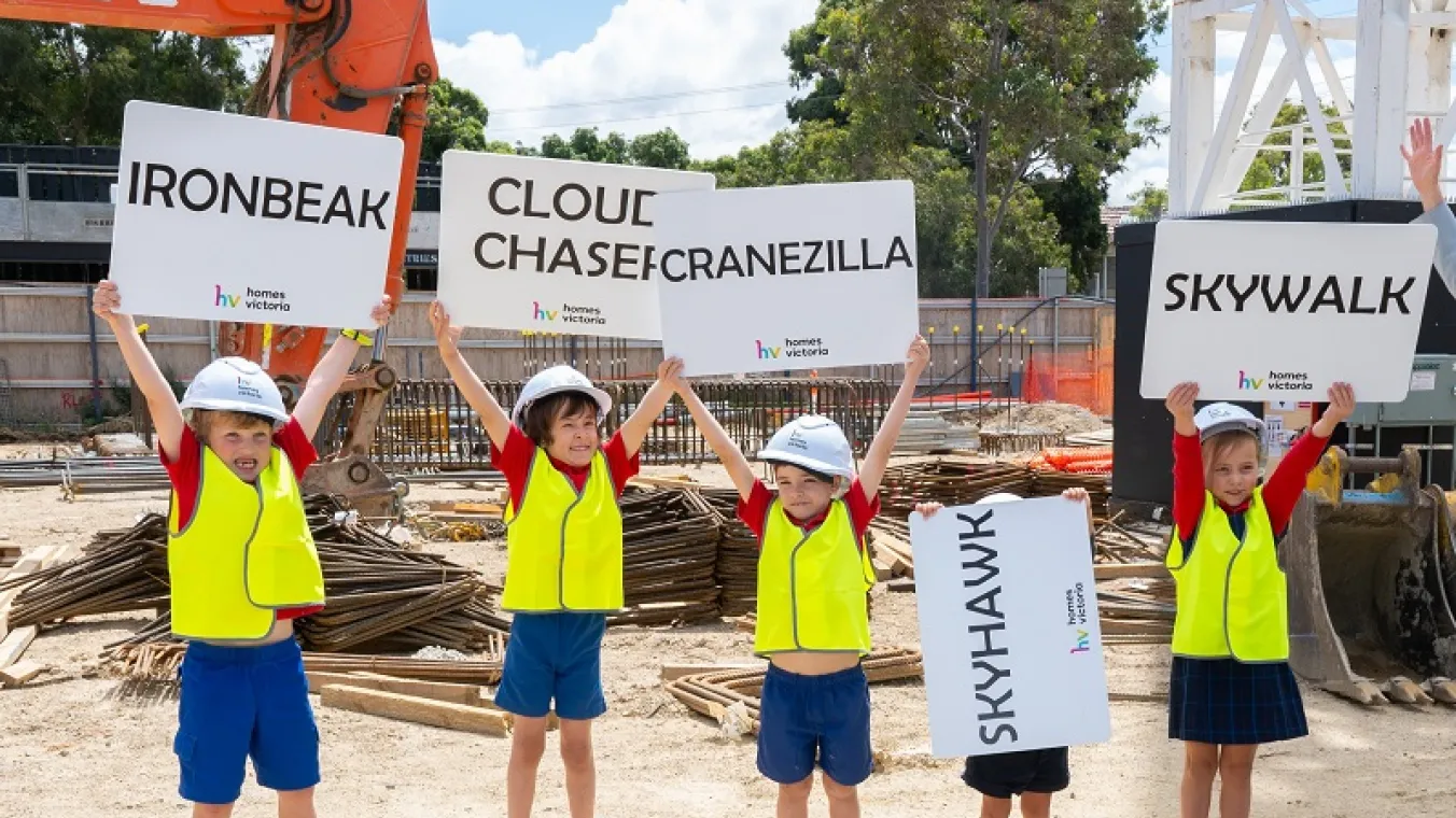 Image of 5 kinds holding banners up high in front of crane