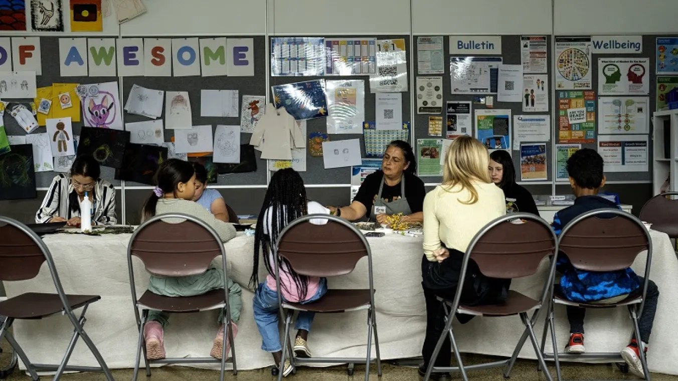 Artists for Kids Culture helping students with their designs, pictured here with Kylie Greer from the artsbus.