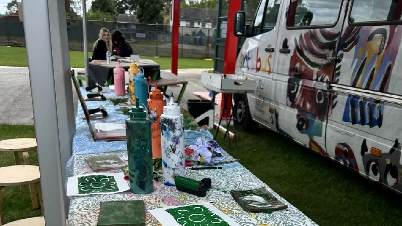 Artists for Kids Culture helping students with their designs, pictured here from the artsbus.