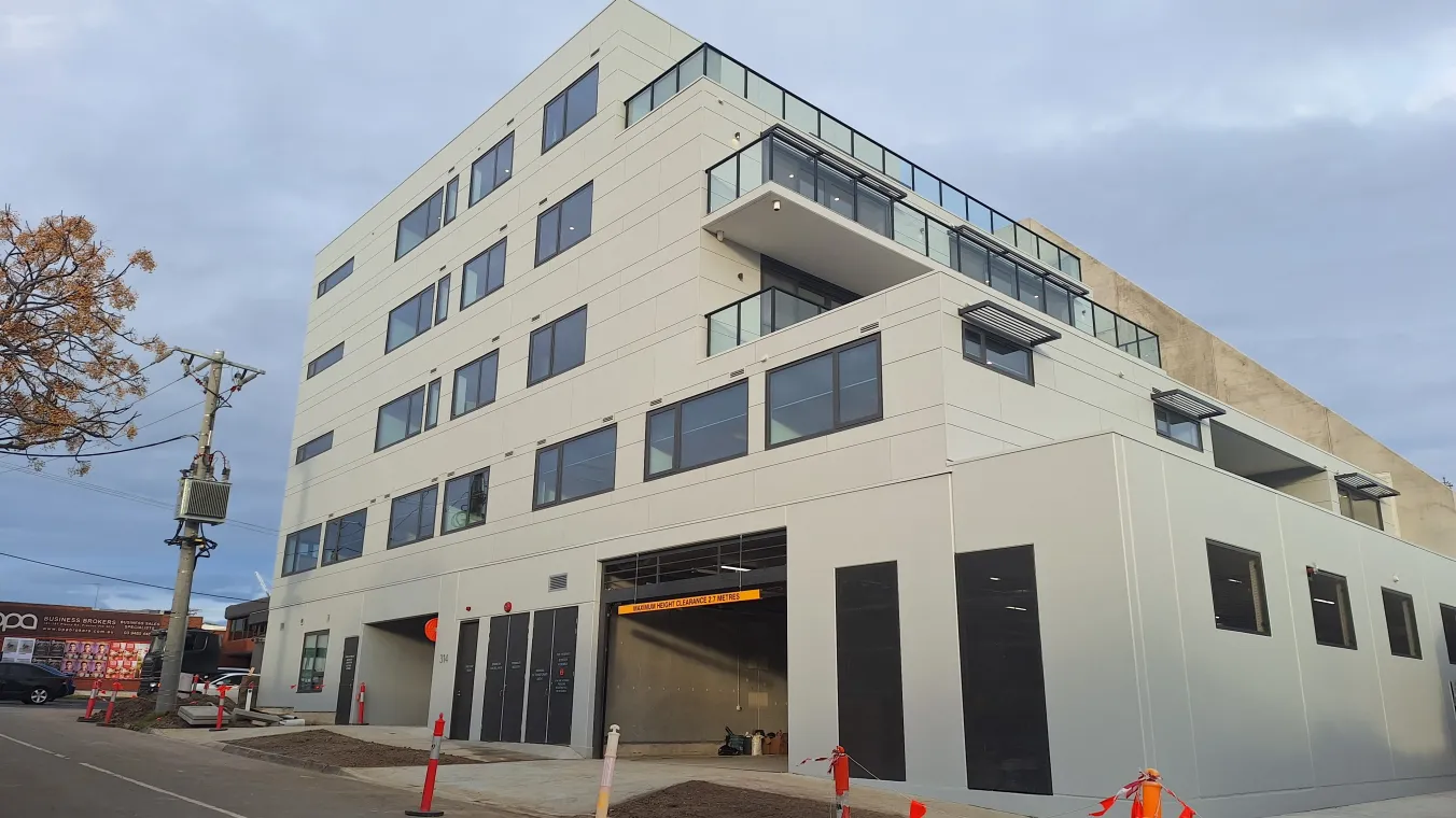 Image of modern social housing apartments in Preston featuring balconies, large windows, and parking area