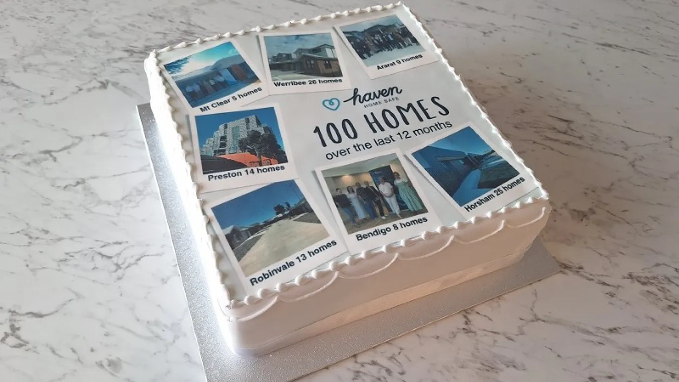 Image of cake with a message written haven home safen100 homes over the last 12 months on it