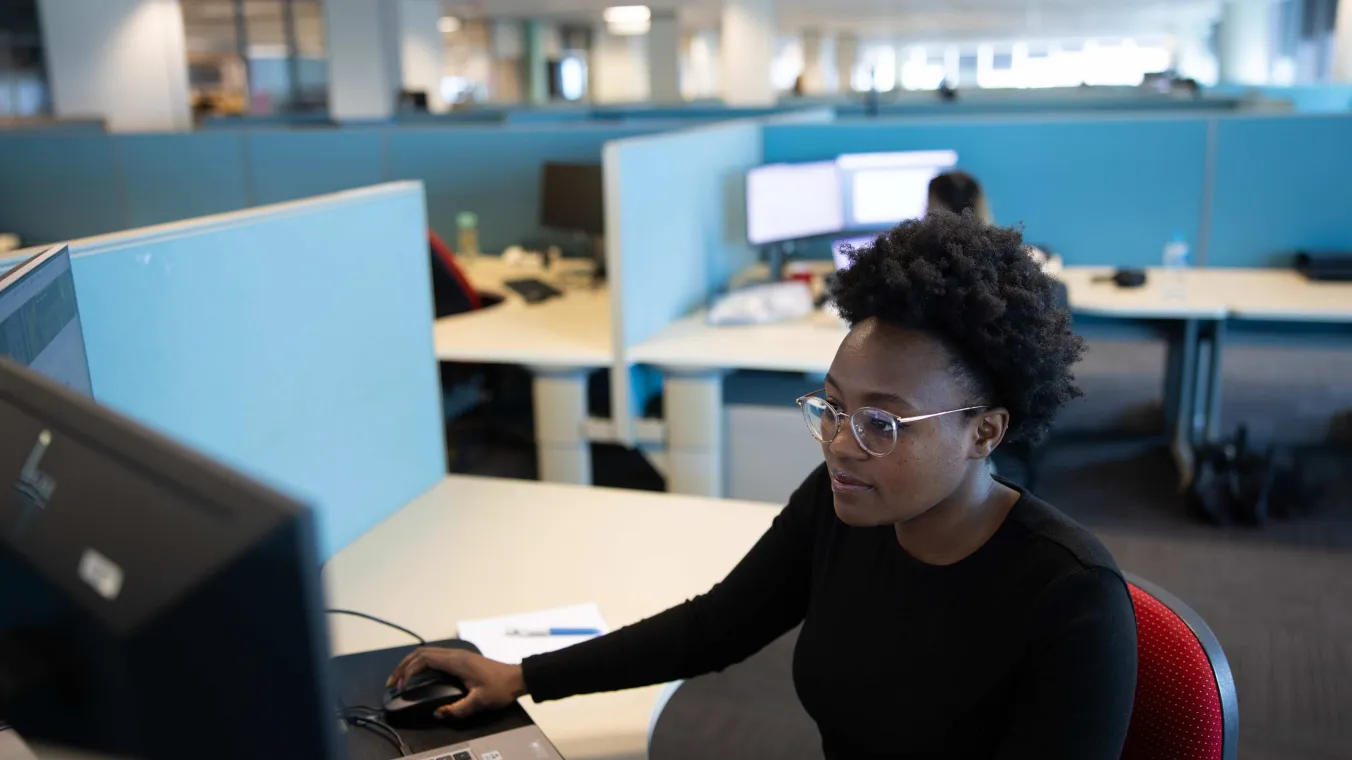 Person sitting behind a computer in an open office