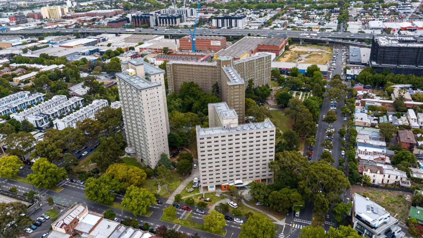 Drone image of 3 housing towers surrounded by homes