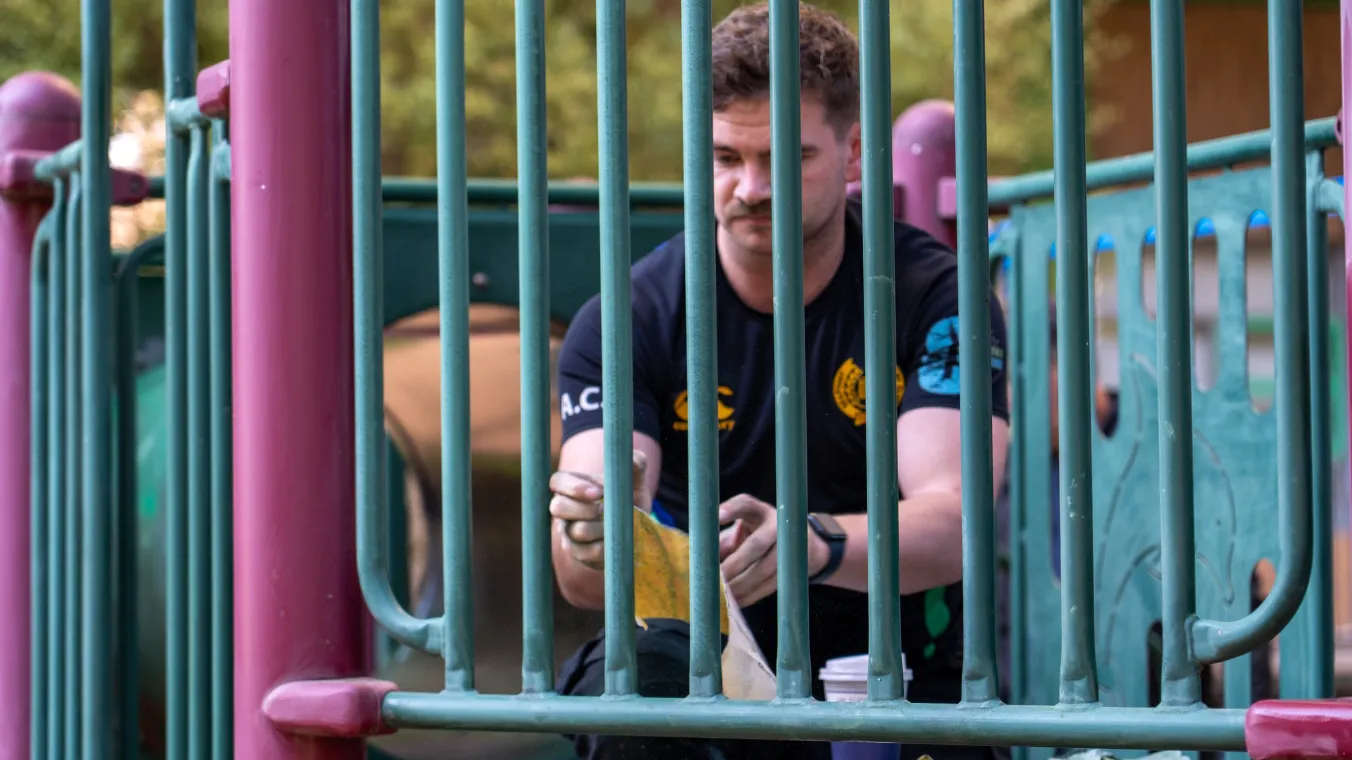 Tradesperson sanding down playground equipment
