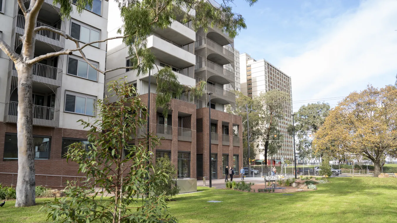 Image of  modern apartment set amid open green spaces and lush landscaped gardens.