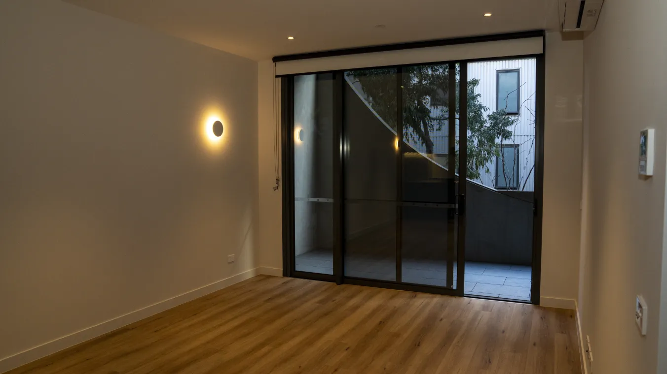 Interior of a modern apartment showcasing a spacious living area that opens onto a balcony.  