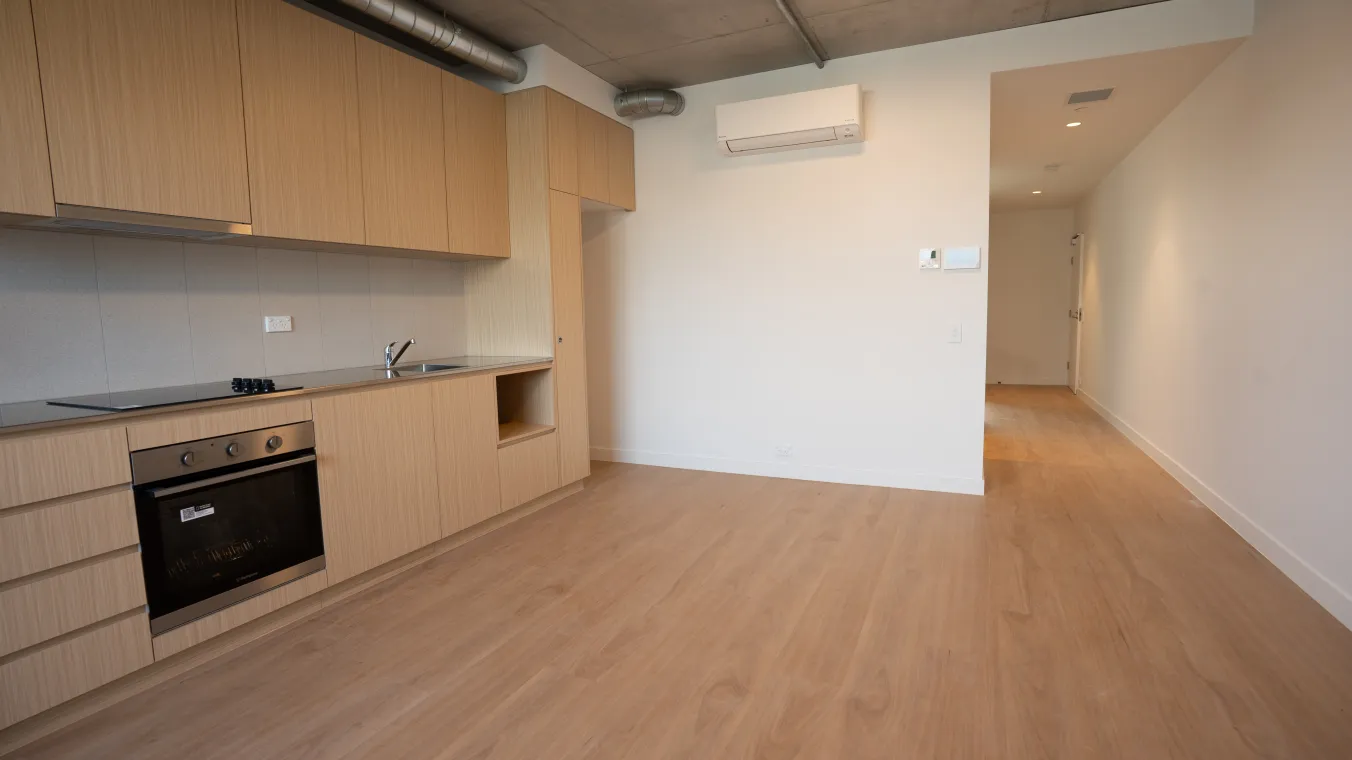 Image of modular kitchen with an electric cooktop, built-in oven, space for a refrigerator, a sink and overhead air conditioner