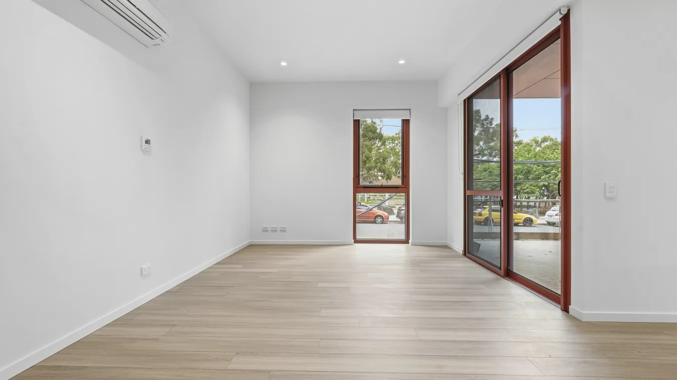 Inside the dining and living area with a window and sliding doors to the outdoor balcony.