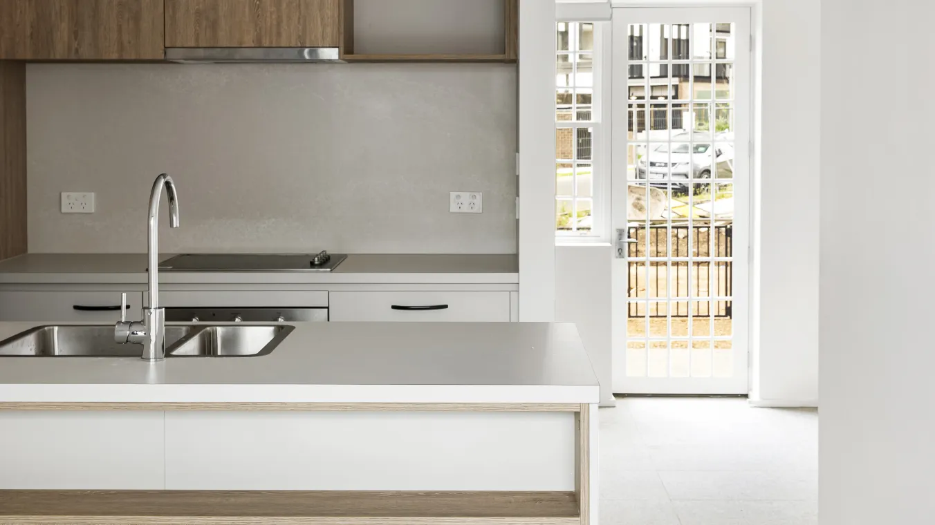 Image of modular kitchen with large glass doors allowing natural sunlight into the interior.  