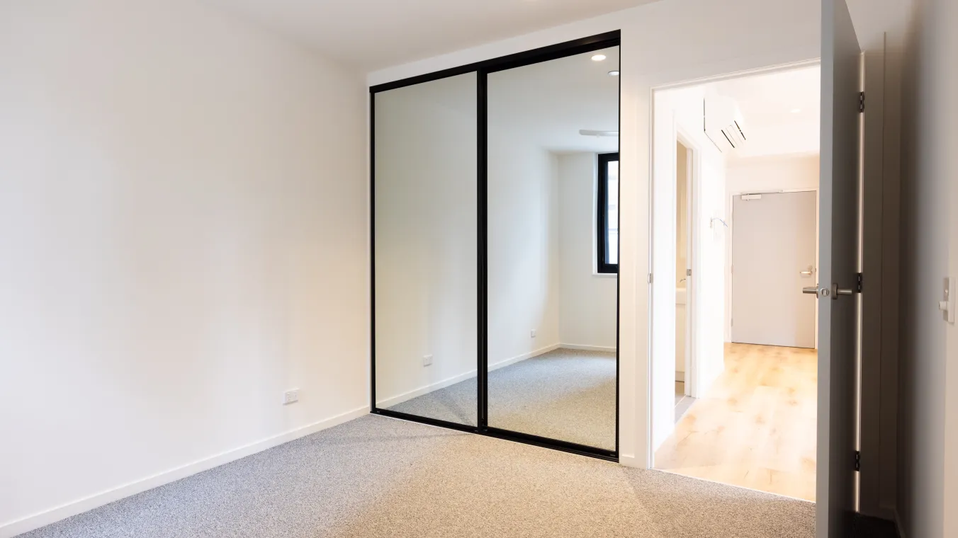 Image of bed room with mirror glass wardrobe, and beautiful carpet