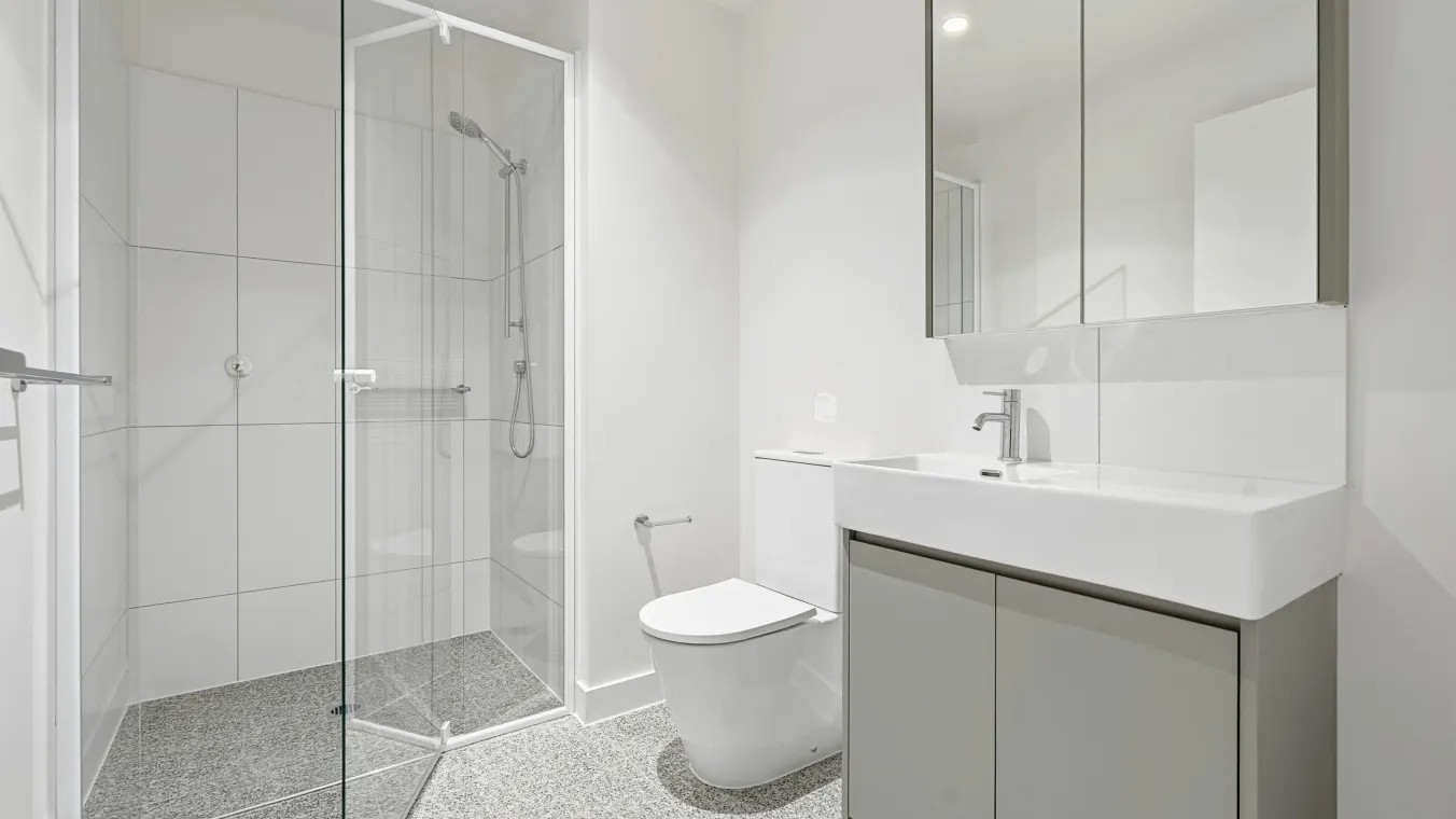 A bathroom with a shower, toilet and sink.