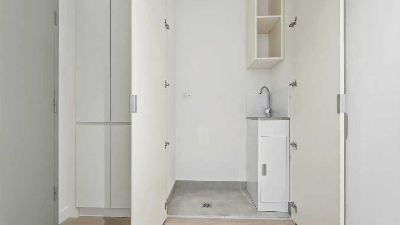 Image of apartment with european laundry with additional storage space.