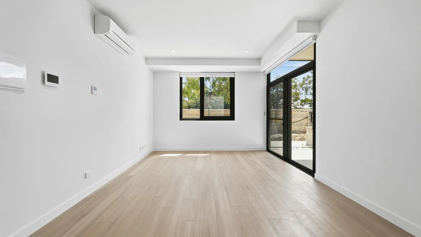 Image of living area with air cone installed on the wall and window and sliding glass door which allows ample of sunlight in