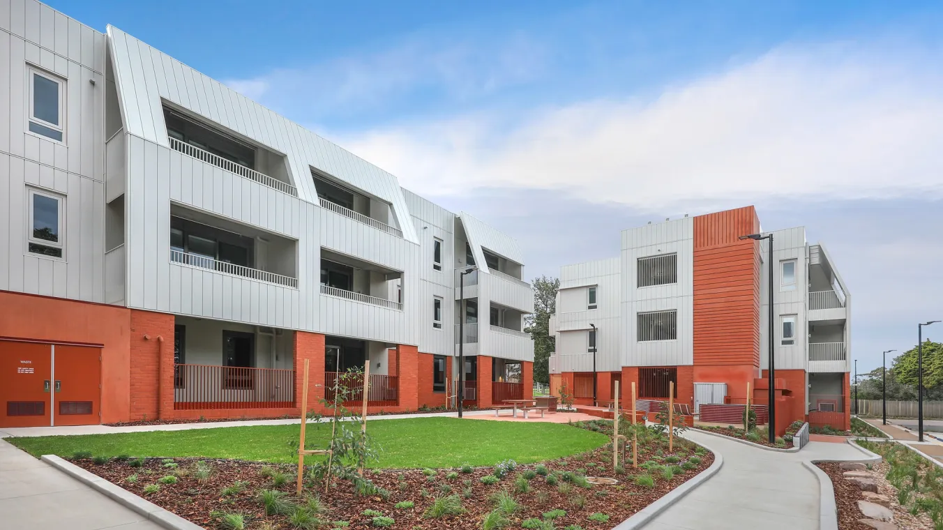 Image of apartment building with balconies and windows, with a beautiful landscaping