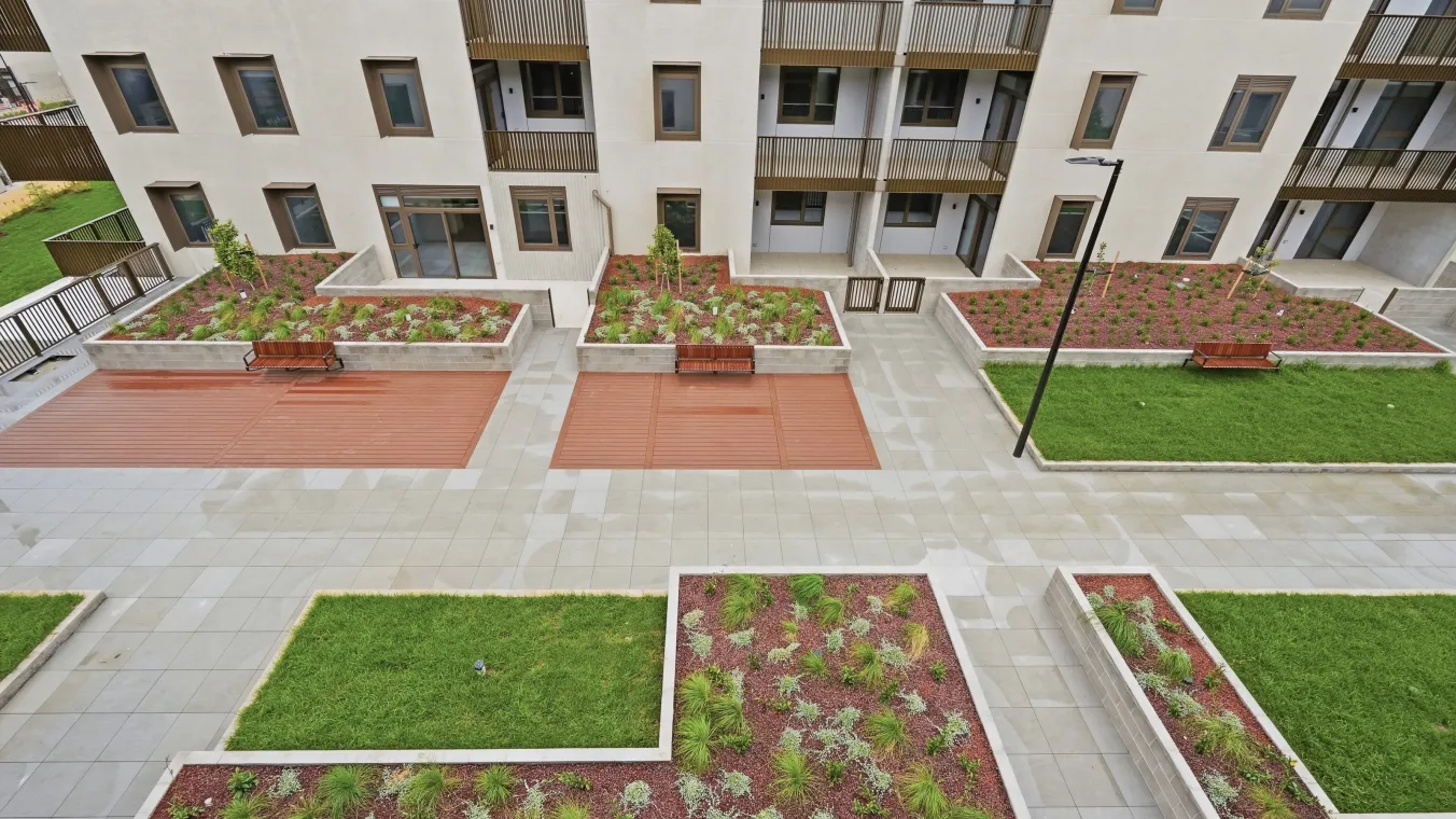 Outdoor shared podium with lawns, benches, and small plant planted