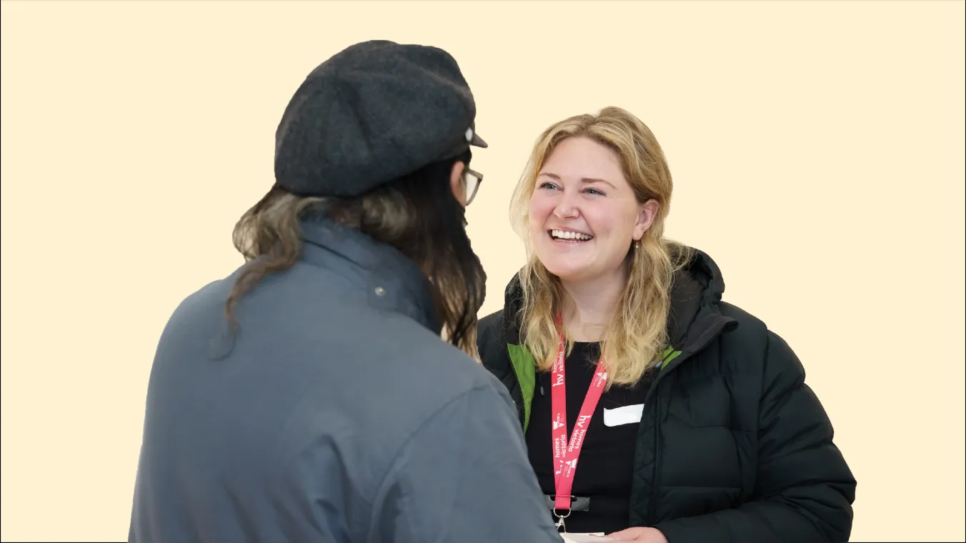 A smiling woman in conversation with another person