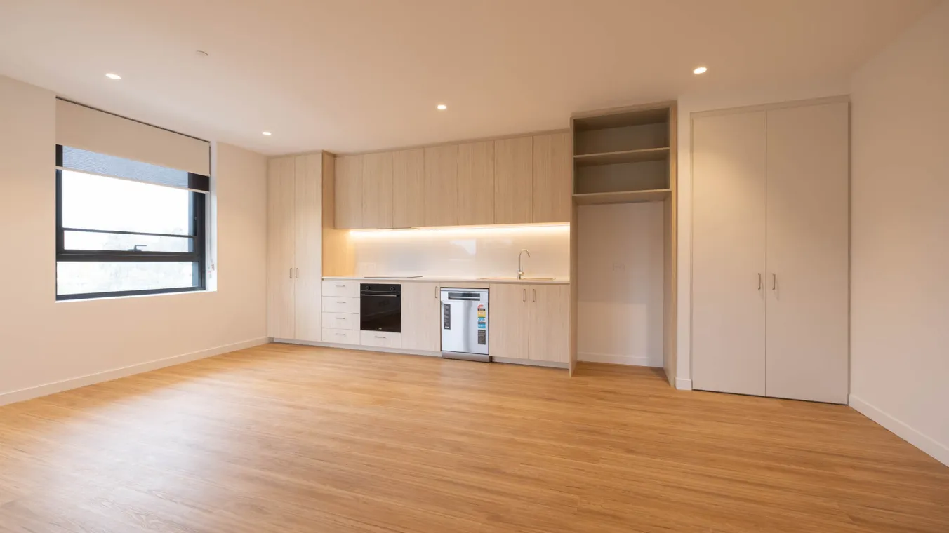 Interior of a new home showing the kitchen with an oven, electric cooktop, rangehood, cabinets,refrigerator space and dishwasher